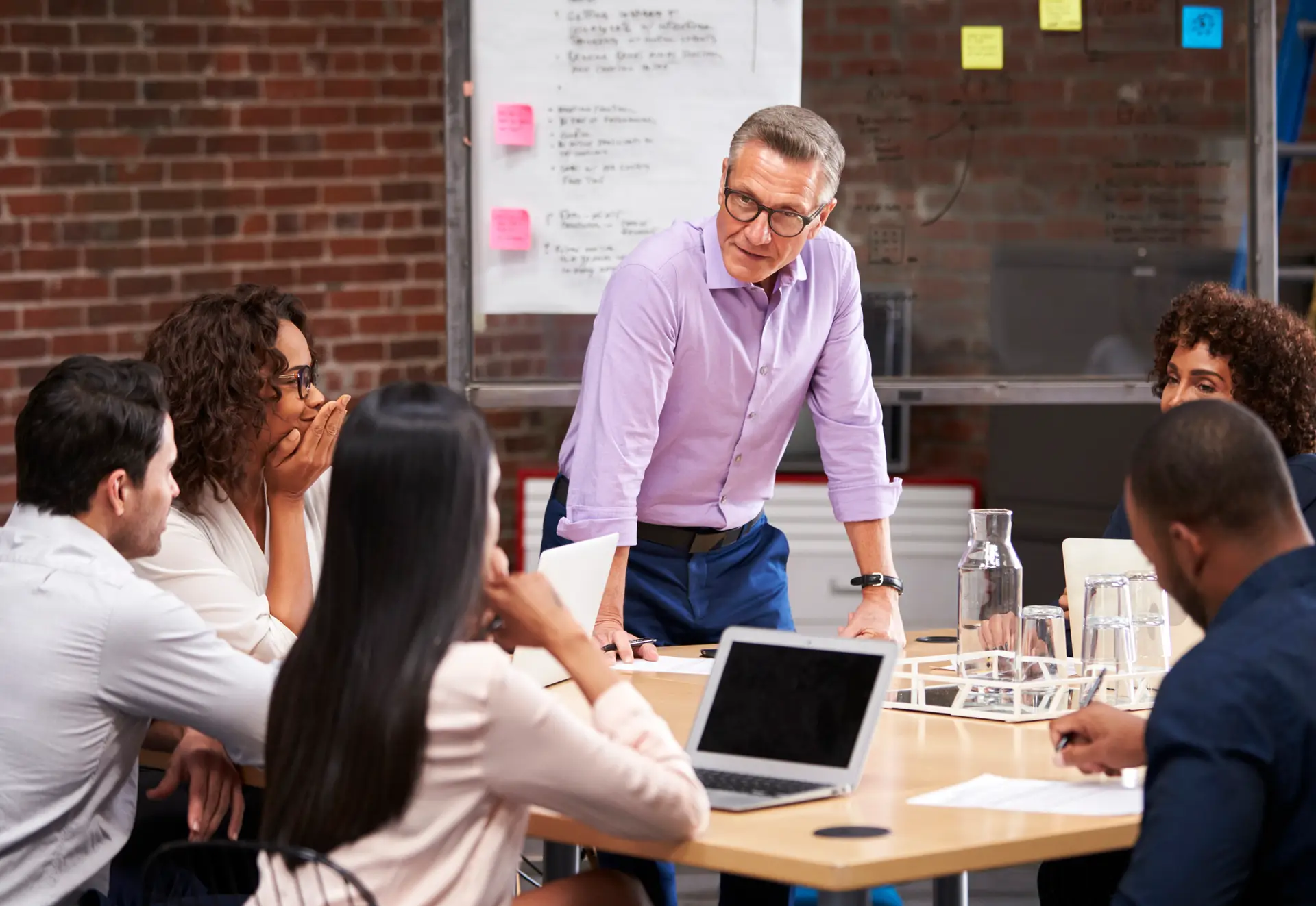 Businessman Standing And Leading Team Meeting , Discussing Systems and Processes. Business Playbook